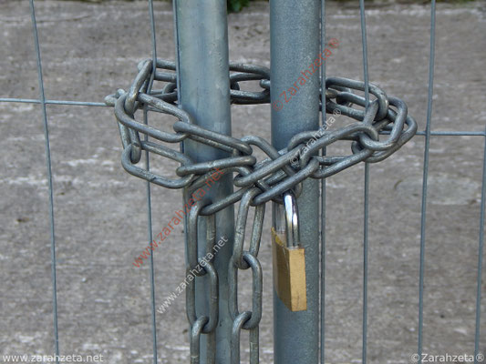 Vorhängeschloss mit Eisenkette am Metallzaun