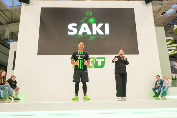 Saki steht mit Moderatorin auf der BKT-Bühne vor großer Leinwand auf der Agritechnica 2025 in Hannover