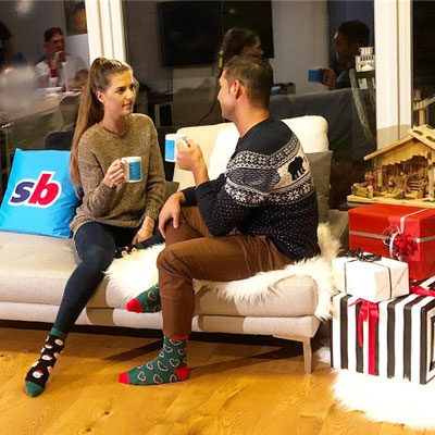 „Fußball Weihnachts-Werbespot – Nahaufnahme der Sportingbet Sofa-Szene mit Tassen und Geschenken“