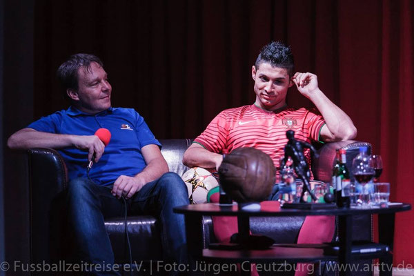 Talkrunde auf der Bühne: Freestyler im roten Trikot auf Sofa, Mikrofon und historischer Lederfußball auf dem Tisch