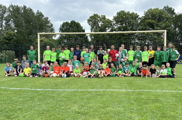 Gruppenfoto mit Fußball-Freestyler Saki, Kindern und Jugendspielern vor dem Tor beim SV GW Kleinenkneten