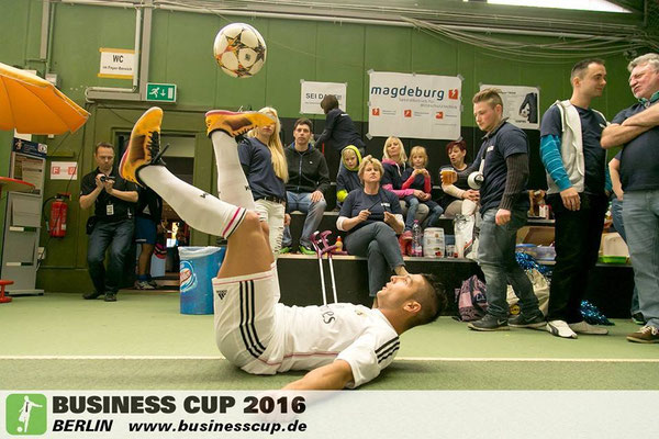 Freestyle-Trick am Boden beim Business Cup: Ballbalance vor Zuschauern in der Halle.
