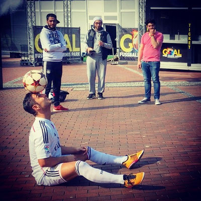 Fußball-Freestyler zeigt Ballkontrolle im Sitzen vor Zuschauern beim GOAL Fußball Erlebnis Park Oberhausen