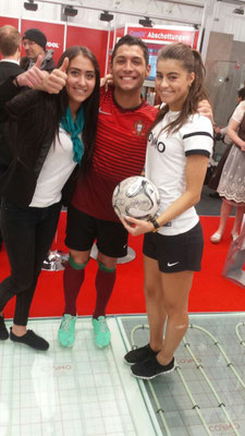 Messestand-Szene der GC-Gruppe in München – Fußball-Freestyler Saki mit Adriana und Cosmo Teammitgliedern im lebendigen Messe-Umfeld.