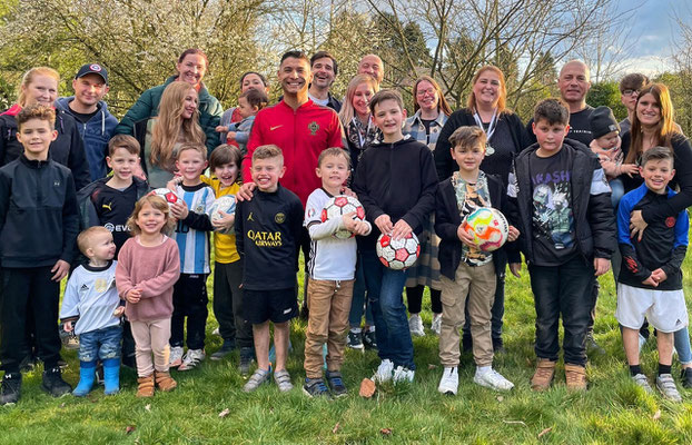 Parents and children posing after an outdoor football birthday celebration