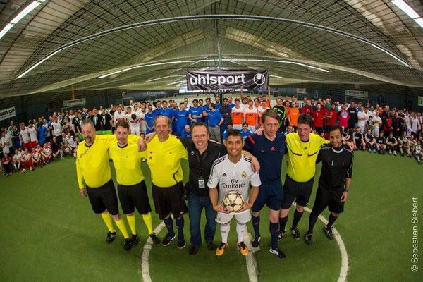 Großes Gruppenfoto aller Teams beim Business Cup in der Soccerhalle – Saki vorne mit Ball.