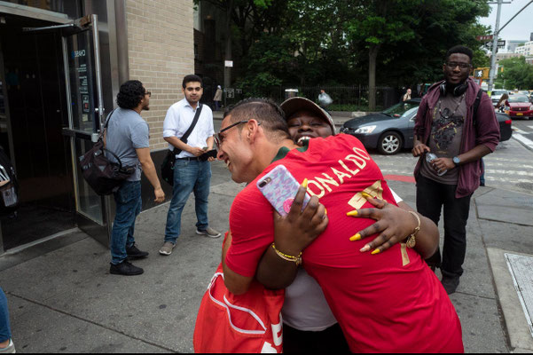 Saki the international Ronaldo double hugging a fan during an event.