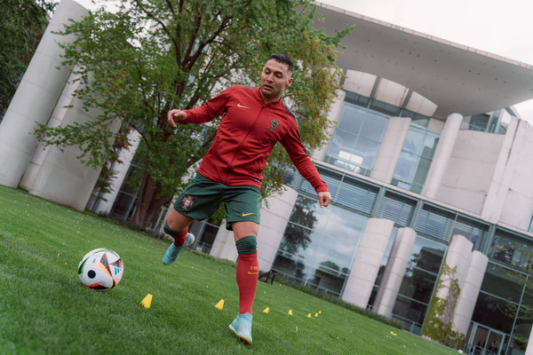 Saki dribbelt mit Fußball auf dem Rasen vor dem Bundeskanzleramt in Berlin