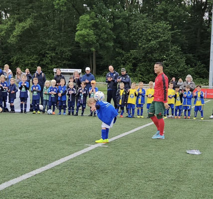 Kind bei einer Ballübung vor Fußball-Freestyler und Kindergruppe auf dem Kunstrasen beim SSV Grefrath