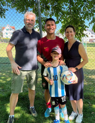 Family photo with entertainer and child in Messi jersey during birthday event