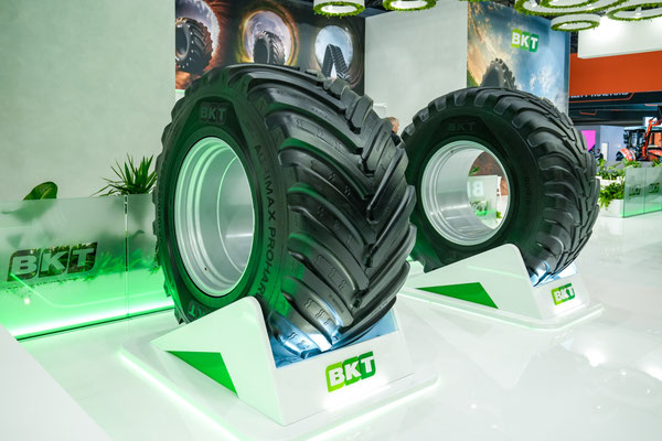 Große Agrarreifen von BKT auf beleuchteten Präsentationsflächen am Messestand der Agritechnica 2025