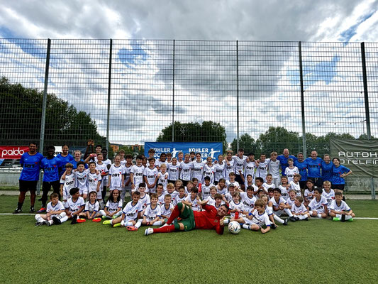 Gruppenfoto mit Fußball-Freestyler Saki, Trainern und vielen Kindern beim Fußballcamp in der Schweiz