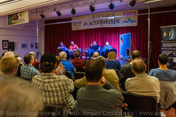 Weitwinkel: Zuschauerraum und Bühne mit Talkgästen, Lichttechnik und rotem Vorhang (Fußballzeitreise e.V.)
