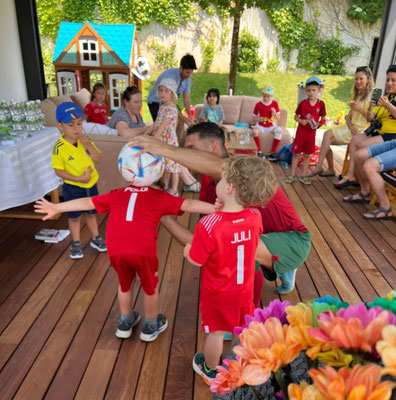 Enfants enthousiastes autour d’un gâteau d’anniversaire sur le thème du football.