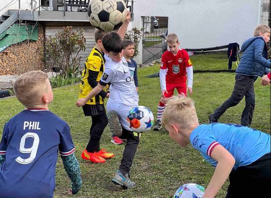 Kids kicking the ball on a garden deck during birthday football activity
