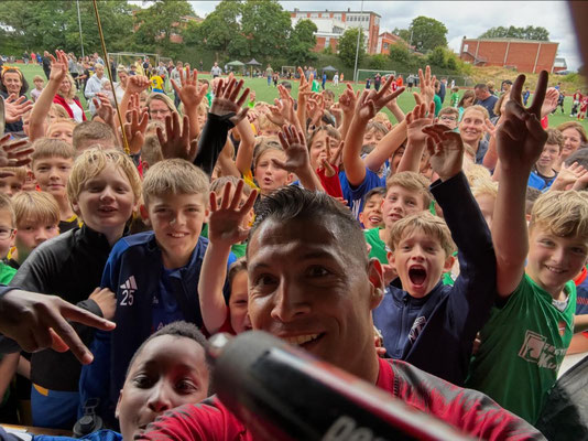 Selfie von Fußball-Freestyler Saki mit vielen jubelnden Kindern beim Fußballturnier des SV Lauenburg
