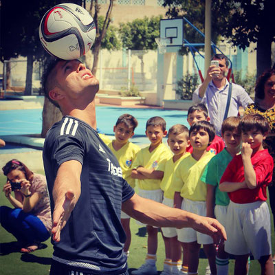 Schüler*innen hören aufmerksam einer Freestyle-Fußball-Vorführung am Stella Maris College Malta zu.