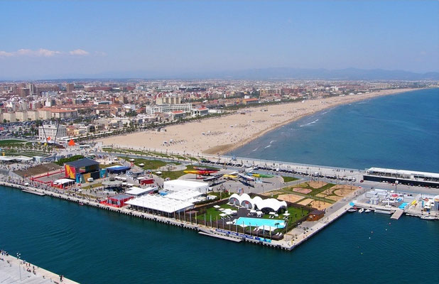 Desde el aire, la playa de la Malvarrosa en Valencia se ve como una extensa franja de arena de color claro, bordeada por una zona de restaurantes y el puerto.