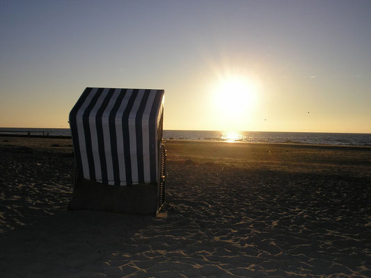 Strandkorb am Weststrand Norderneys mit Blick in den Sonnenuntergang