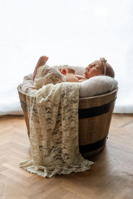 Neugeborenes Baby liegt geborgen auf der Decke im Wochenbett in Leipzig
