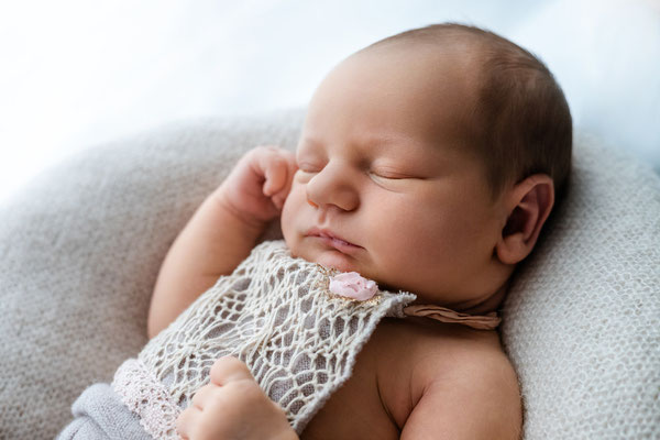 Neugeborenes Baby liegt geborgen auf der Decke im Wochenbett in Leipzig