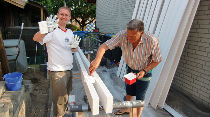 Bauherren streichen das Holz vom neuen Carport