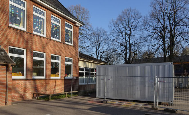 Die Lehrerinnen schauen in ihren Pause auf die Toilettencontainer.