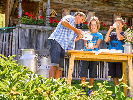 Jungen trinken Milch an der Simonalm