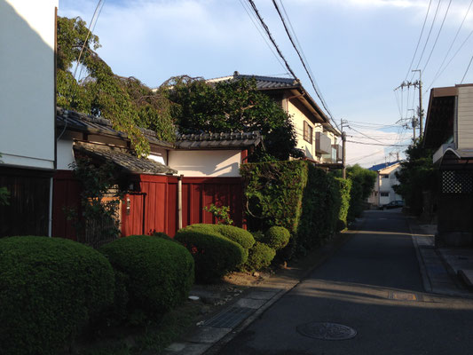 河合家住宅（長岡京市粟生）。門の朱塗りと白壁の土蔵が印象的だ。文化財説明板があります。