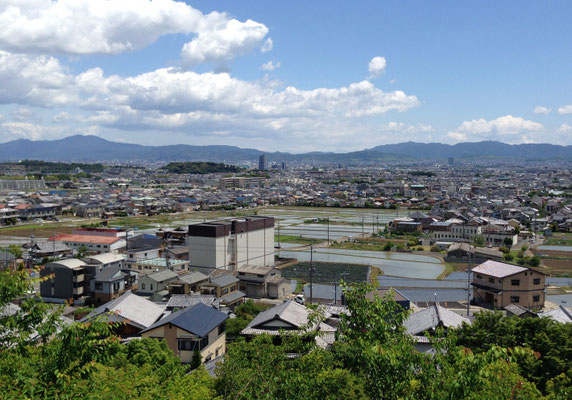 西山公園体育館から長岡京跡をみる。細長い向日丘陵が横たわる。はるか向こうは比叡山と東山が連なる。