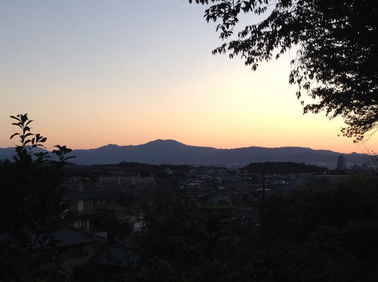 西山公園体育館から朝焼けのシルエット。右側の山並みは東山、手前の岡は向日丘陵。
