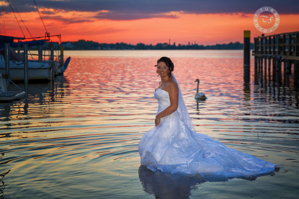 Braut im Wasser mit Schwan im Sonnenuntergang Caputh