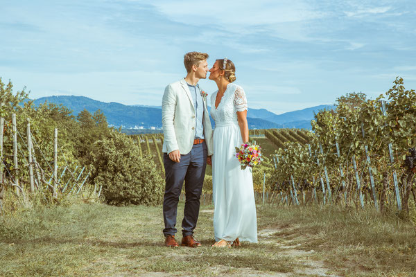 Hochzeitsfoto von Anja und Guido mit Kuss in den Reben von Timo Erlenwein Fotografie