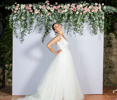 bride in front of photobooth flowers