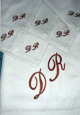 L'Atelier de Couture Nadine GRATACAP. Initiales brodé en broderis blanche sur nappe et serviettes.