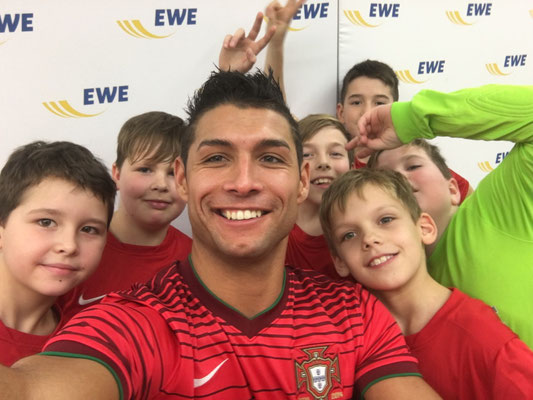 Gruppenfoto der teilnehmenden Teams beim EWE Cup 2016 in Brandenburg zusammen mit Fußball-Freestyler Saki – Jugendturnier, Teamgeist und Fußball-Gemeinschaft in Aktion.