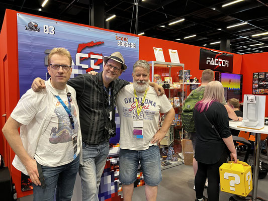 Lutz Osterkorn,  Chris Huelsbeck und Willi Bäcker von Factor 5 sind auf diesem Bild zur Männerquatsch Podcast [Sonderfolge] Gamescom 2022: Der Retro Rundgang, alle Aussteller zu sehen.
