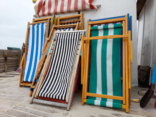 Bunte Liegestühle können am Strand pro Tag günstig gemietet werden