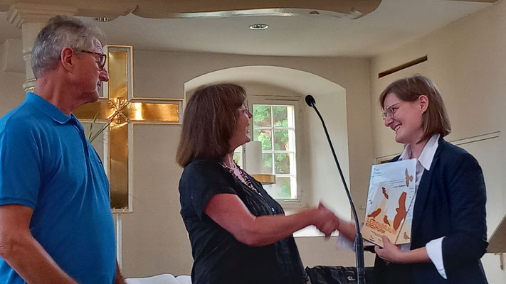 Foto: Iris Rothe - Dagmar Reduth vom NABU (Mitte) übergibt die Kirchenplakette an Pfarrerin Nadine Kempf
