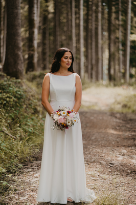 Braut im Brautkleid mit Brautstrauß am Waldweg im Schwarzwald