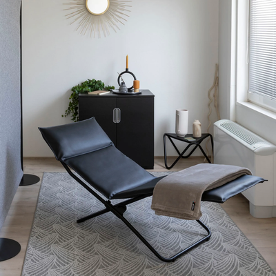 Collaborateur en position Zéro Gravité sur une chaise longue Lafuma noire dans une salle de repos professionnelle.