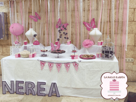 Mesa dulce comunion en Cartagena. Candy bar comunion en Cartagena. Tarta de comunion, decoracion mariposas, cupcakes, cakepops, cookies, bagel, golosinas, decoracion rosa y blanco. Photocall comunion, fotos. La dulce ilsuion