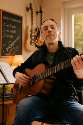 Marco Nau - Foto - Mit Gitarre im Unterrichtsraum der Gitarrenschule Ma-Guitar in Mannheim