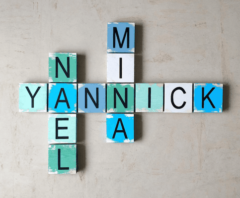 Scrabble mural peint en bleu, blanc et vert, avec prénoms personnalisé en noir, sur un fond clair