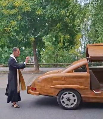 Le curé Don Arnaud bénit la Mercedes en bois.
