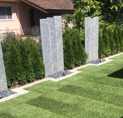 Sichtschutz aus Granit in einem Garten am Zürichsee. Garteneinfassungen um den Rasen wurden ebenfalls erneuert, damit das Mähen wieder einfach geht. Sichtschutz aus Holz oder Stein ist auch möglich je nach Landschaftsgegebenheiten oder Kundenwünschen.