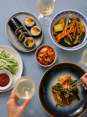 Gimbap, Japchae und Kimchi auf einem gedeckten Tisch während eines koreanischen Kochkurses von Bilou Kitchen in München.