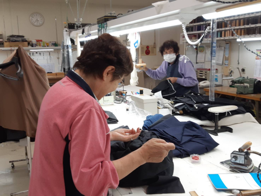 有限会社サン・ソーイング　伊予鉄高島屋で女性スタッフが婦人服・紳士服の補正作業を行う風景写真画像