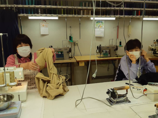 有限会社サン・ソーイング　伊予鉄高島屋で男性スタッフが婦人服・紳士服の補正作業を行う風景写真画像
