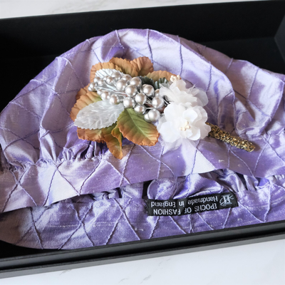 Regency-style silk bonnet in lilac with decoration, laying in black box